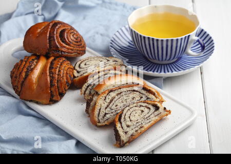 Panneaux et rouleaux ensemble les graines de pavot et une tasse de thé vert Banque D'Images