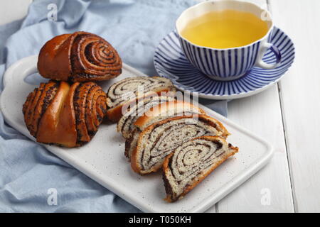 Panneaux et rouleaux ensemble les graines de pavot et une tasse de thé vert Banque D'Images