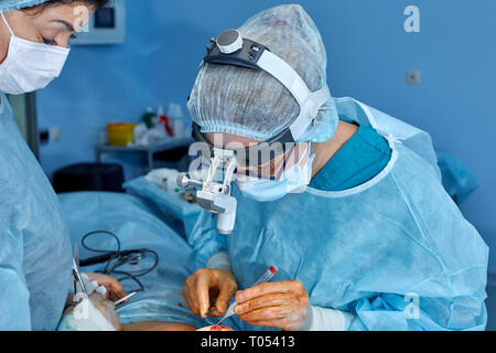 Portrait of surgeons coud le patient après la chirurgie. Concept de la chirurgie. Les chirurgiens pendant une intervention chirurgicale sur un fond bleu Banque D'Images