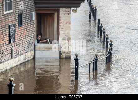 Un membre du personnel de la Kings Arms à York pompe hors de l'eau inondation après la rivière Ouse éclate ses banques, comme des avertissements d'inondation restent en place à travers le Royaume-Uni. Banque D'Images