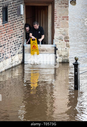 Le personnel de la Kings Arms à York regardent l'eau des crues s'élève après la rivière Ouse éclate ses banques, comme des avertissements d'inondation restent en place à travers le Royaume-Uni. Banque D'Images