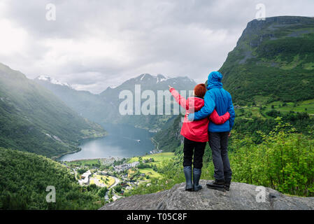 Vue sur le village touristique à Geiranger, Norvège. Les touristes sont à un point panoramique et regarder les montagnes et le Geirangerfjord Banque D'Images