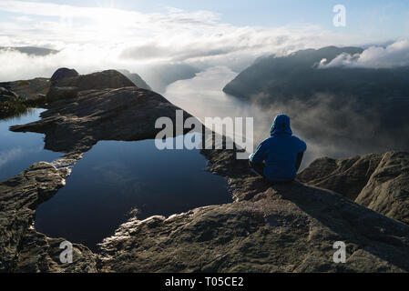 Près de Preikestolen (Pulpit Rock), la célèbre attraction touristique à Ryfylke, domine le Lysefjord. Guy sur un rocher regarde au loin et bénéficie d Banque D'Images