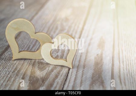 Deux coeurs en bois sur une table en bois. Symobl pour l'amour et de la famille. Banque D'Images