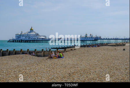 Eastbourne, Sussex, England, UK - 1 août 2018 : La vue de la plage de la jetée. Famille picnicing sur la plage au premier plan. Cliché pris sur un Banque D'Images