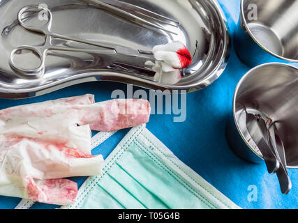 Chirurgie ciseaux avec torunda imbibé de sang sur un plateau métal dans une salle d'opération, la composition horizontale, conceptual image Banque D'Images