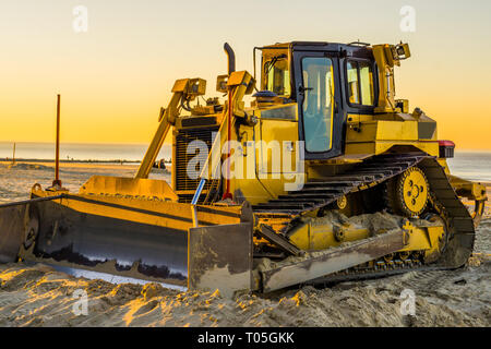 Bulldozer jaune avec une boule au coucher du soleil sur la plage, l'équipement de sol, de l'industrie bases Banque D'Images
