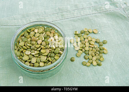 Diviser les pois verts dans un plat en verre sur de vieilles serviettes en lin Banque D'Images