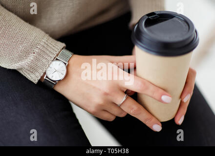 Femme tenant un verre de café dans les mains. Banque D'Images