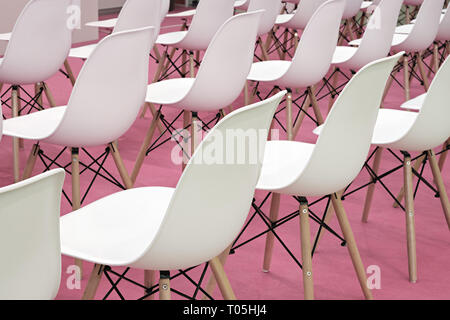 Des chaises blanches conférence en salle d'affaires, des rangées de sièges confortables en plastique blanc vide en présentation corporative bureau réunion, détail, sélective fo Banque D'Images