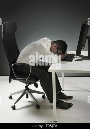 Épuisé businessman having a pan sur le bureau Banque D'Images