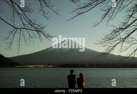 Yamanashi, Japon - 01/05/2019 : un couple à la recherche sur le lac Kawaguchi à Mt. Fuji dans la distance. Banque D'Images