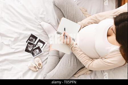 Pregnant woman making liste d'expédition pour l'hôpital de maternité Banque D'Images