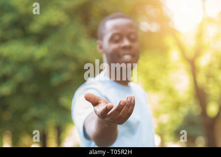 Cheerful black man atteindre sa main à l'appareil photo Banque D'Images