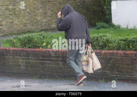 Londres, Royaume-Uni. Mar 17, 2019. Un homme de marcher à Londres comme la grêle commence à tomber : Crédit Dinendra Haria/Alamy Live News Crédit : Dinendra Haria/Alamy Live News Banque D'Images