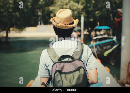 Retour de jeunes male solo traveler marche sur chemin vers l'île tropicale en Thaïlande. Banque D'Images