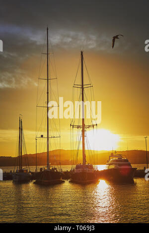 La lumière au coucher du soleil avec de grands voiliers dans un port espagnol de la ville de Palamos sur la Costa Brava Banque D'Images