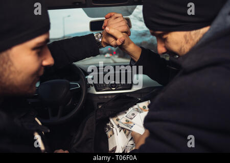 Après le succès du vol de banque, les voleurs sont dans la voiture montrant outre de leur argent et de célébrer la victoire sur le droit qu'ils avaient. Banque D'Images