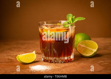 Thé glacé froid dans un verre sur un fond brun foncé. Close-up. Focus sélectif. Banque D'Images