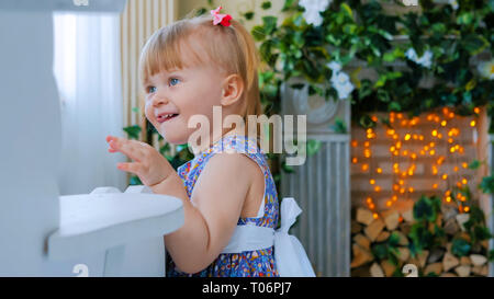 Petite fille jouant avec cheval à bascule en bois blanc Banque D'Images