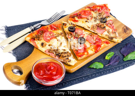 Tranches de pizza sur planche de bois sur un jean. Studio Photo Banque D'Images