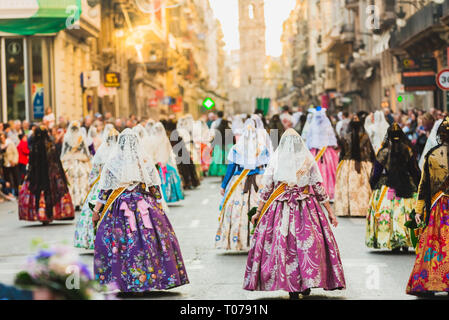 Valencia, Espagne - 17 mars 2019 : plusieurs milliers de femmes Falleras qui défilent en bas de la rue de La Paz avec leurs robes espagnoles typiques de Valence lors de l'offrande de Fallas à la Vierge, vus de derrière. Credit : Joaquin Corbalan pasteur/Alamy Live News Banque D'Images