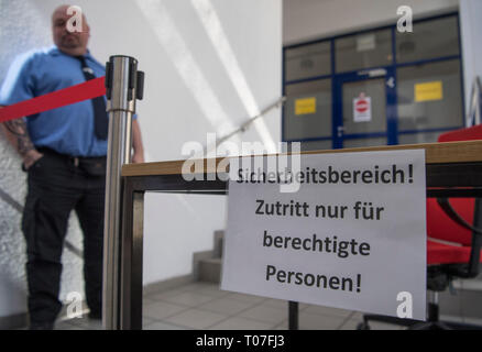 Mainz, Germany. 18th Mar, 2019. A security guard is standing in front of an already closed-off building section of the Federal Network Agency, in which 41 frequency blocks will be auctioned off to various providers starting Tuesday (19 March). The auction will last several weeks. 5G is of great importance for German industry. Credit: Boris Roessler/dpa/Alamy Live News Banque D'Images