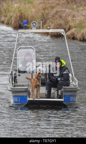 18 mars 2019, le Brandebourg, Wolzig : sur un bateau, des agents de police avec un chien renifleur continuent leur recherche de l'absence de Rebecca sur le canal près du lac Wolziger Storkower Voir dans le district de Dahme-Spreewald. Photo : Patrick Pleul/dpa-Zentralbild/ZB Banque D'Images