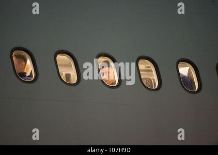 Glasgow, Royaume-Uni. 18 Mar, 2019. Liam Palmer (centre) à bord de la fenêtre avec l'équipe de football de l'Ecosse vu prendre l'avion de luxe avion privé dans les premières heures vu à l'aéroport de Glasgow quelques instants avant de partir pour le Kazakhstan pour jouer un match le mercredi. Le vol était due à décoller à 11h00, mais en raison d'un problème imprévu où le pilote a dû sortir de la cabine de pilotage et sur le tarmac et parler avec le personnel au sol, le vol s'est finalement éteint dans les premières heures d'aujourd'hui. Crédit : Colin Fisher/Alamy Live News Banque D'Images