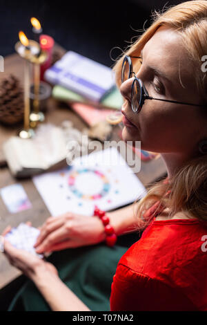 Close up of mature belle astrologue sentiment occupé à travailler à la maison Banque D'Images