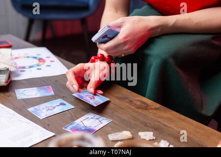 Vue de dessus de woman wearing red bracelet lecture cartes oracle Banque D'Images