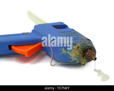 Vieux pistolet à colle chaude utilisée avec l'accent sur la colle fondue dégoulinant isolé sur fond blanc Banque D'Images