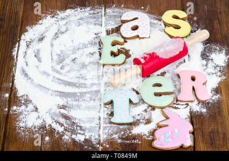 Des biscuits en forme de lettres et les oeufs de Pâques sur vieux bois backgroun. Banque D'Images