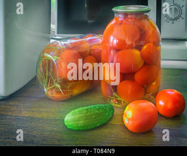 Accueil préservation : grands pots en verre avec des tomates marinées mûr rouge, couvercle métallique scellée. Banque D'Images