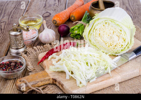 Tranches de chou chinois, carottes, épices pour la cuisson sur planche de bois. Studio Photo Banque D'Images