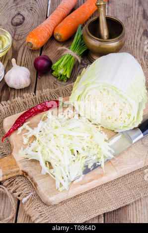 Tranches de chou chinois, carottes, épices pour la cuisson sur planche de bois. Studio Photo Banque D'Images