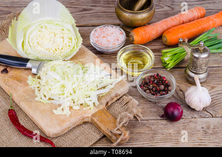 Tranches de chou chinois, carottes, épices pour la cuisson sur planche de bois. Studio Photo Banque D'Images