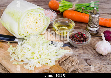 Tranches de chou chinois, carottes, épices pour la cuisson sur planche de bois. Studio Photo Banque D'Images