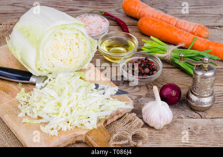 Tranches de chou chinois, carottes, épices pour la cuisson sur planche de bois. Studio Photo Banque D'Images