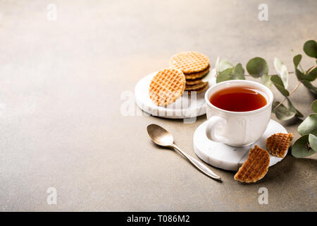 Tasse de thé avec syrupwaffles cookies Banque D'Images