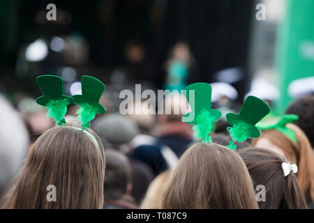 Gens portant des bandeaux St Patricks day à une St Patrick's Day event Banque D'Images