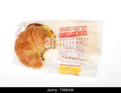Burger King Saucisse, Œuf et fromage croissant CROISSAN'WICH avec bouchée et wrapper sur fond blanc Banque D'Images