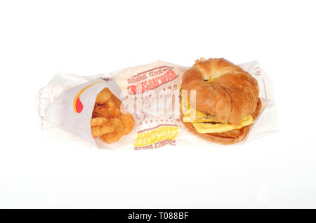 Burger King Saucisse, Œuf et fromage CROISSAN'WICH et pommes de terre rissolées avec des enveloppes sur fond blanc Banque D'Images