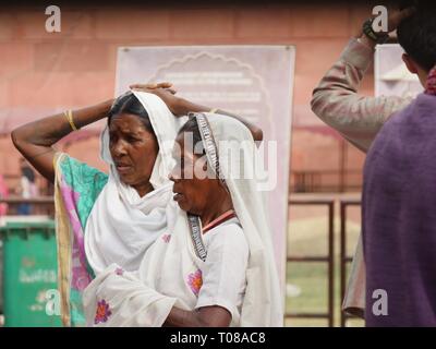 AGRA, UTTAR PRADESH, INDE--MARS 2018: Les femmes portant des saris indiens traditionnels attendent d'acheter des billets pour le Taj Mahal. Banque D'Images