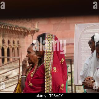 AGRA, UTTAR PRADESH, INDE--MARS 2018: Les femmes portant des saris indiens traditionnels colorés tombent dans la ligne au comptoir de billets au Taj Mahal. Banque D'Images