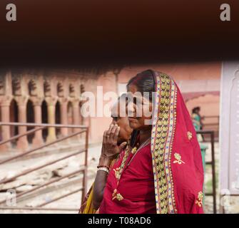 AGRA, UTTAR PRADESH, INDE--MARS 2018: Gros plan de deux femmes portant des saris indiens traditionnels colorés tombent au Taj Mahal. Banque D'Images