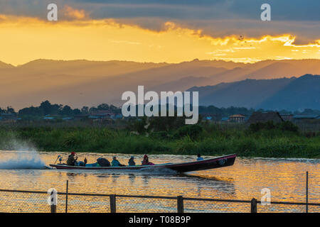 Longue queue canoe pleine de touristes descendre rapidement sur le lac Inle, Myanmar Banque D'Images