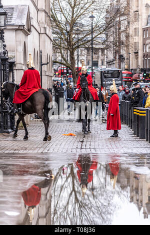 Relève de la Garde cérémonie montés après de fortes pluies. Traduit par flaque. Les gardiens de la vie de la Household Cavalry en hiver manteaux uniforme Banque D'Images