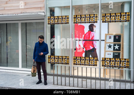 31.12.2017, Tokyo, Kanto, Japon - Un homme est debout devant une vitrine dans le comté de Shibuya en regardant son téléphone cellulaire. 0SL171231D064CAROEX.JPG [MO Banque D'Images