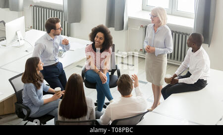 Les gens d'affaires groupe de discussion sur le plan de travail avec l'entraîneur à la réunion Banque D'Images